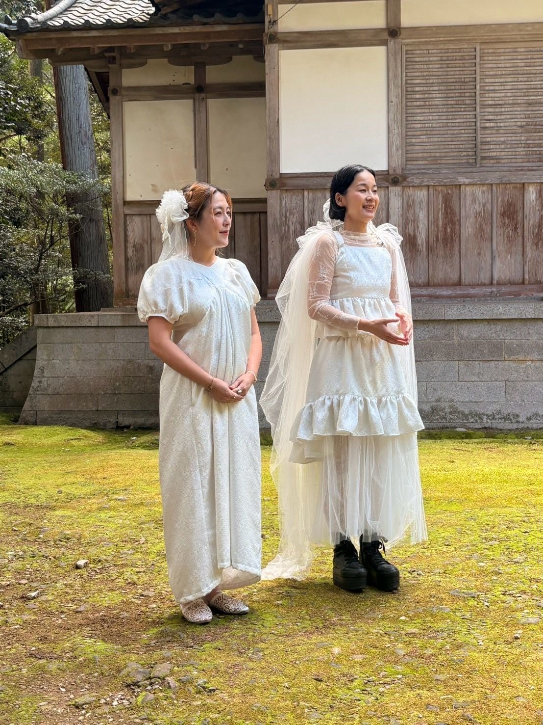 苔の広がる神社の境内で、白い衣装をまとって並ぶ mogmin. と ViVi