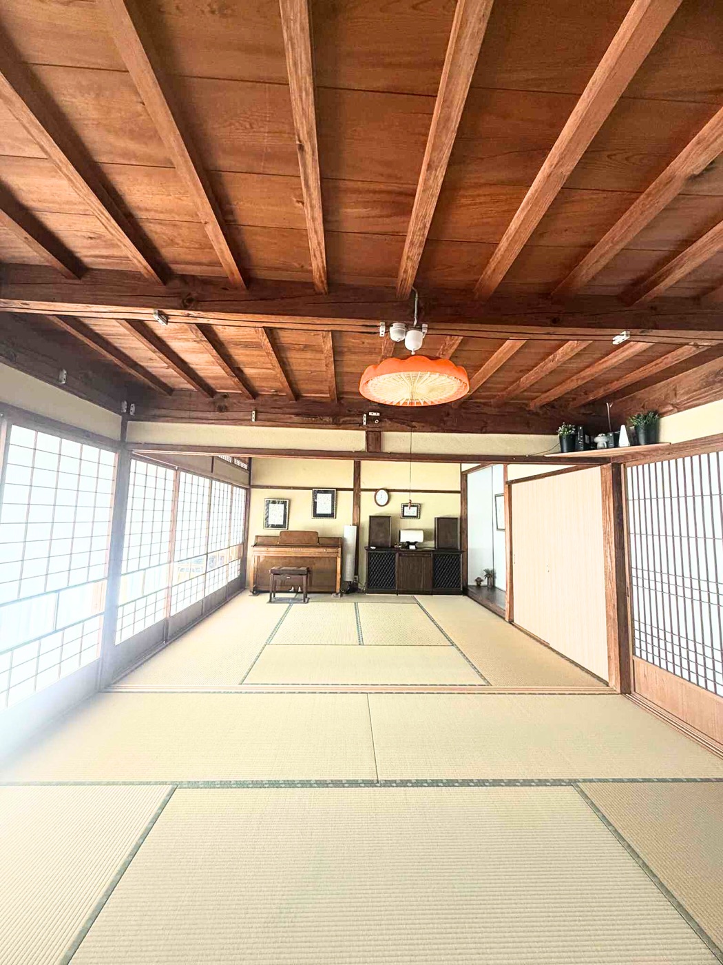 木の梁と障子に囲まれた、KAMIGOTO HOUSE の広い畳の間