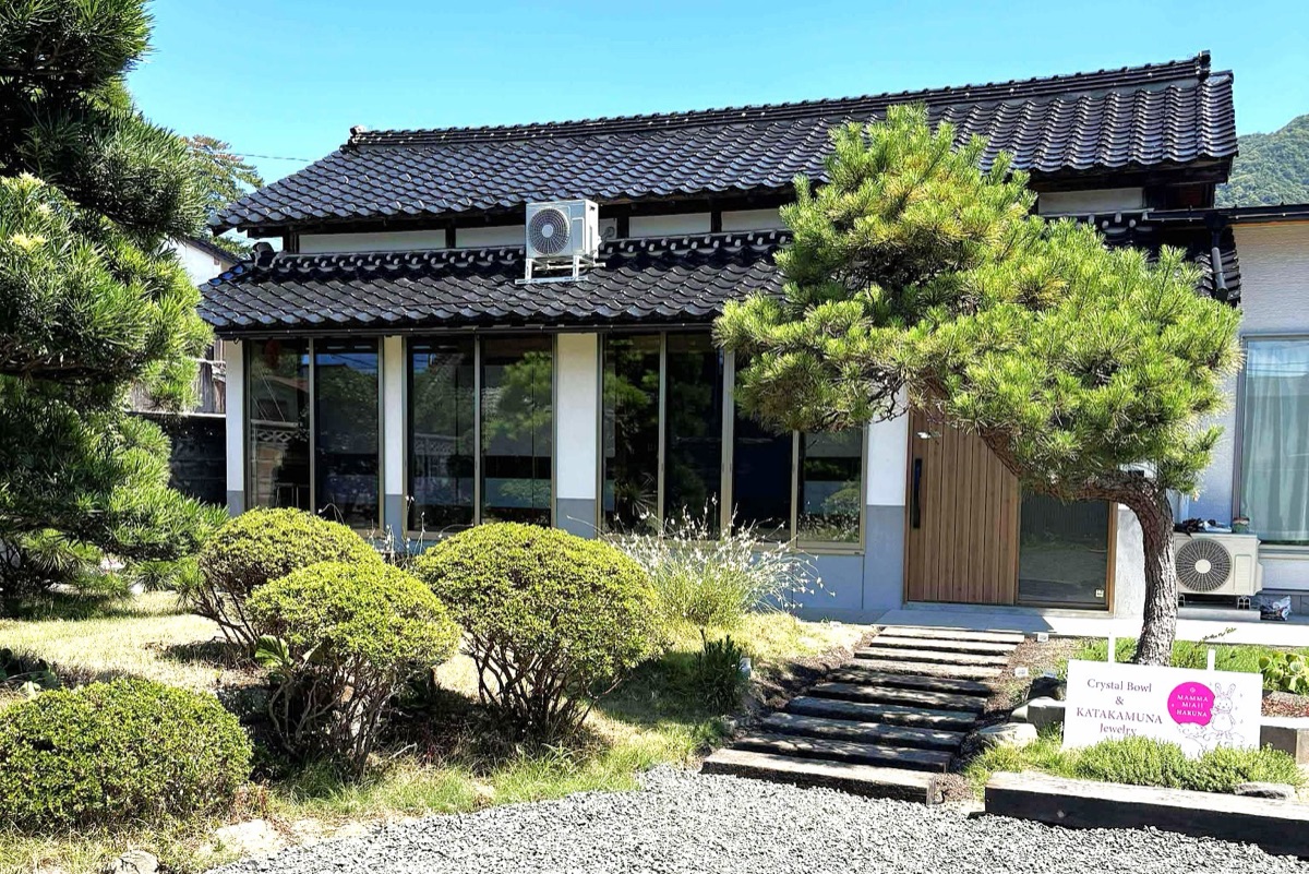 松と植え込みのある KAMIGOTO HOUSE の外観
